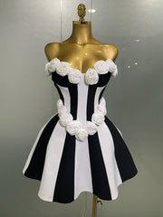 Black and white striped dress with floral details on a mannequin against a gray background