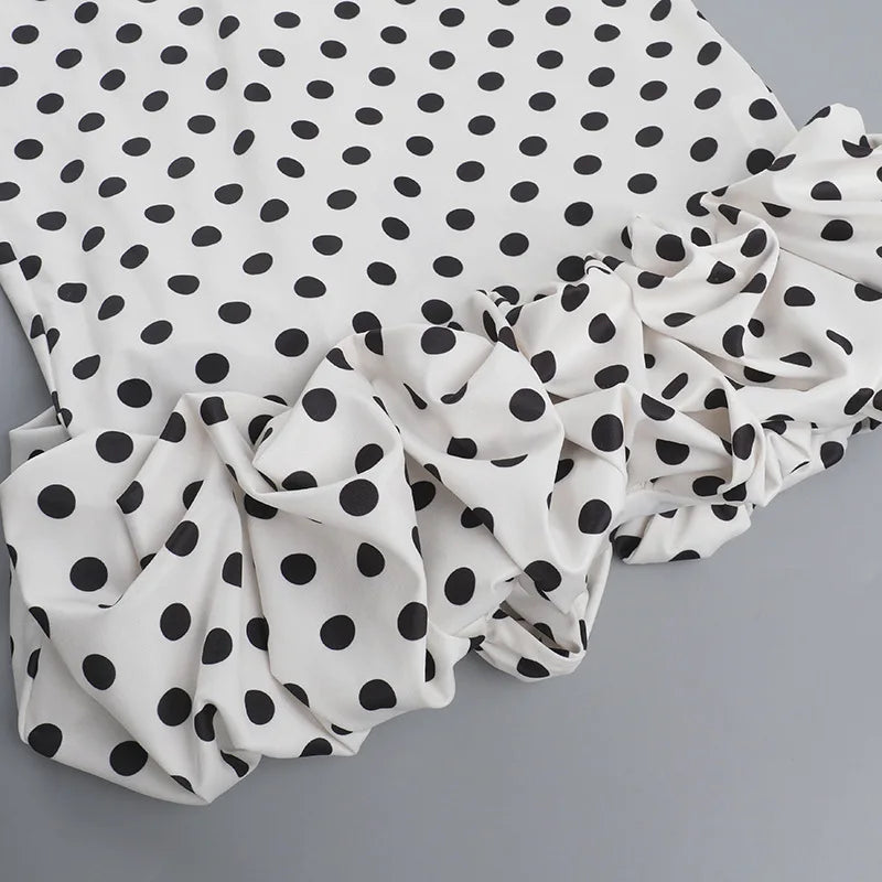 White fabric with black polka dots on a gray background