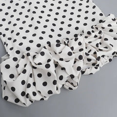 White fabric with black polka dots on a gray background