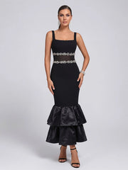 Close-up of pearl and mesh detailing on the waist of a black midi dress.
