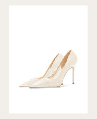 Pair of white high-heeled shoes on a light beige background
