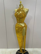 Gold dress on a mannequin against a white background
