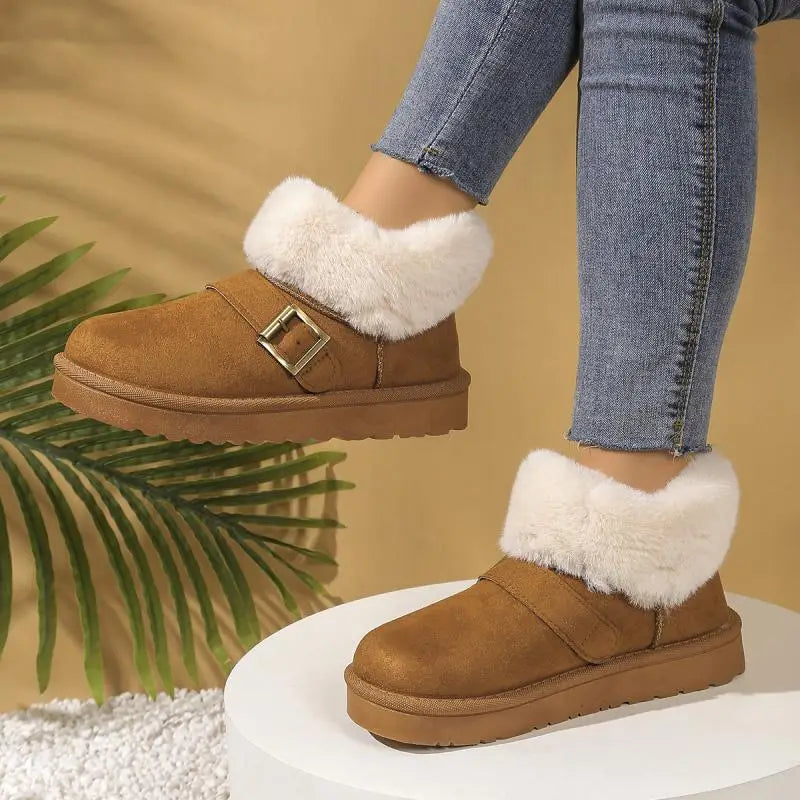 Brown suede boots with white fur trim worn by a person in jeans against a beige background.