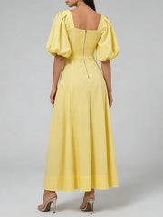 Yellow dress with puff sleeves on a gray background