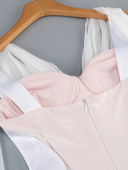 Light pink dress on a hanger against a gray background