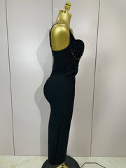 Black evening gown with beaded details on a mannequin against a plain background