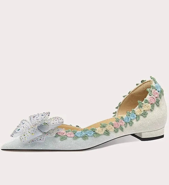 Decorative flat shoe with floral embellishments on a white background
