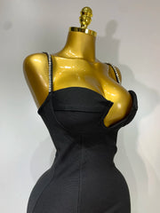 Black dress on a gold mannequin against a white background