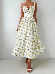 White dress with yellow floral pattern worn by a person on a plain background
