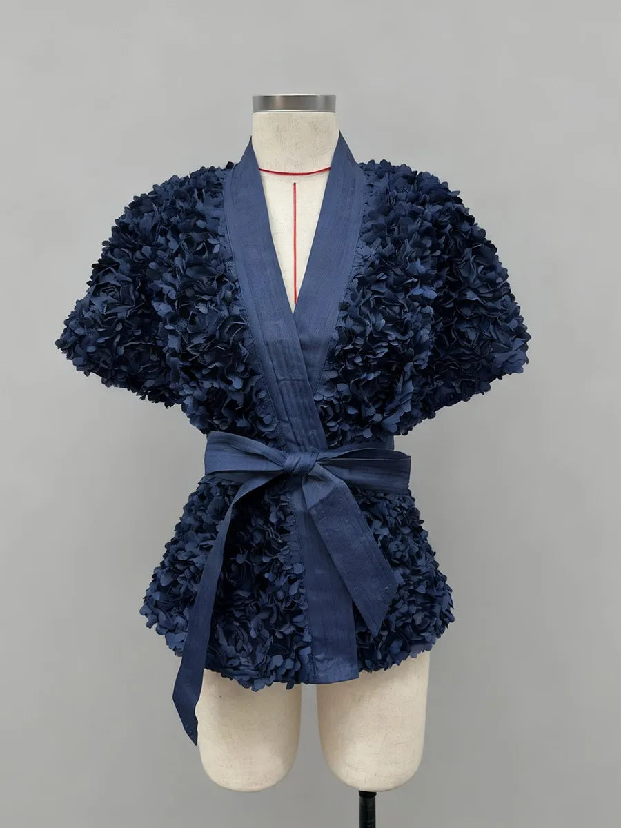 Navy blue textured dress on a mannequin against a gray background