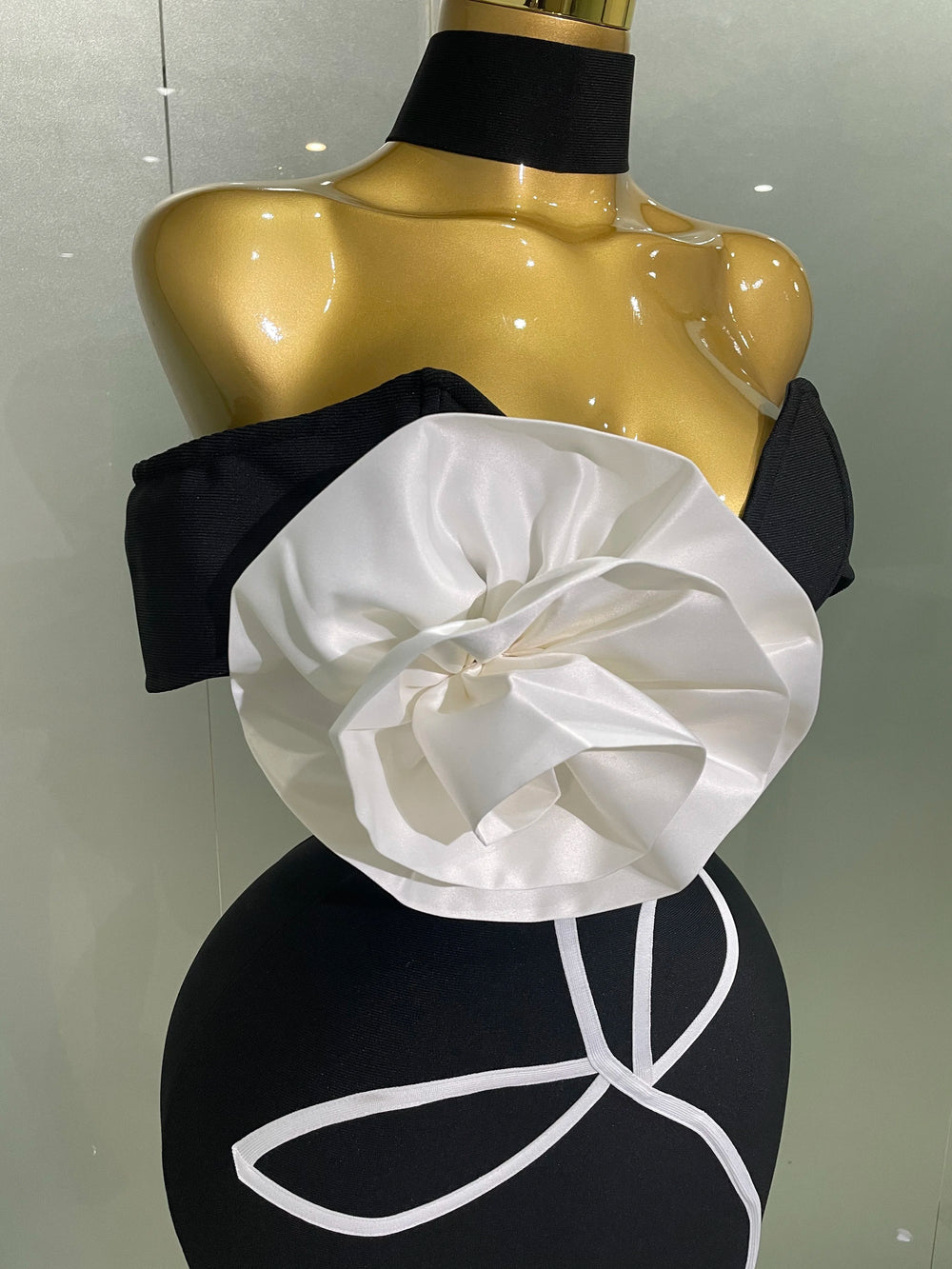 Black and white floral top on a mannequin against a neutral background