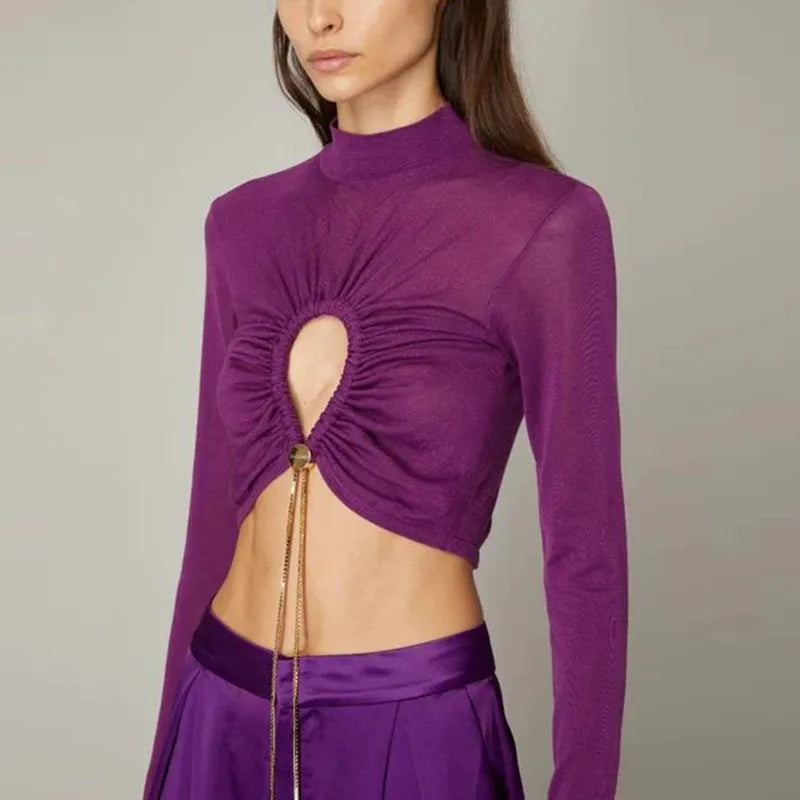 Purple long-sleeve top with cut-out design on a neutral background