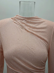 A mannequin wearing a apricot mesh top against a plain background