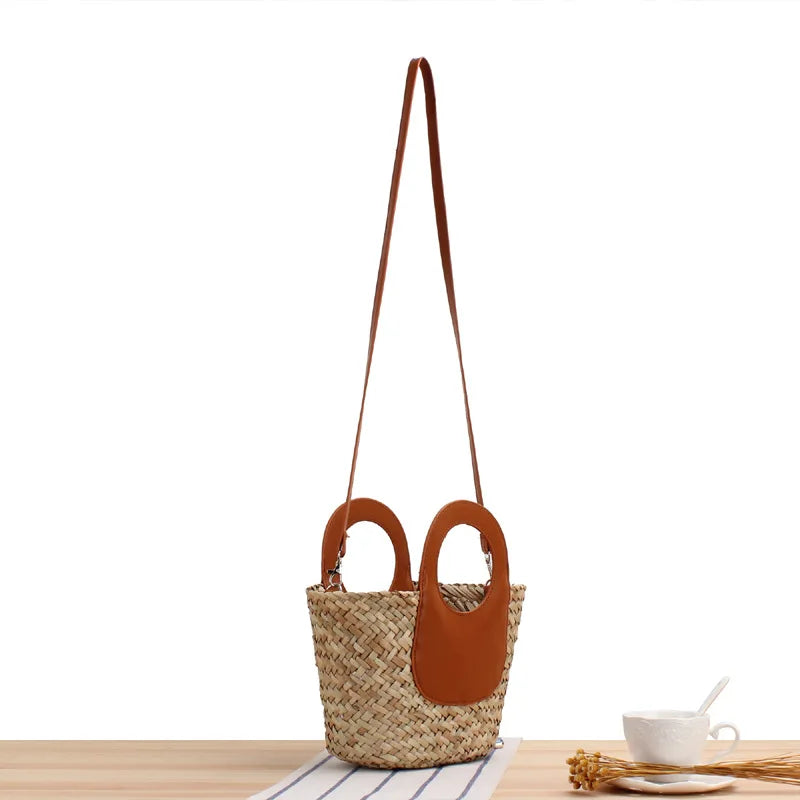 Woven bag with brown leather accents on a wooden surface