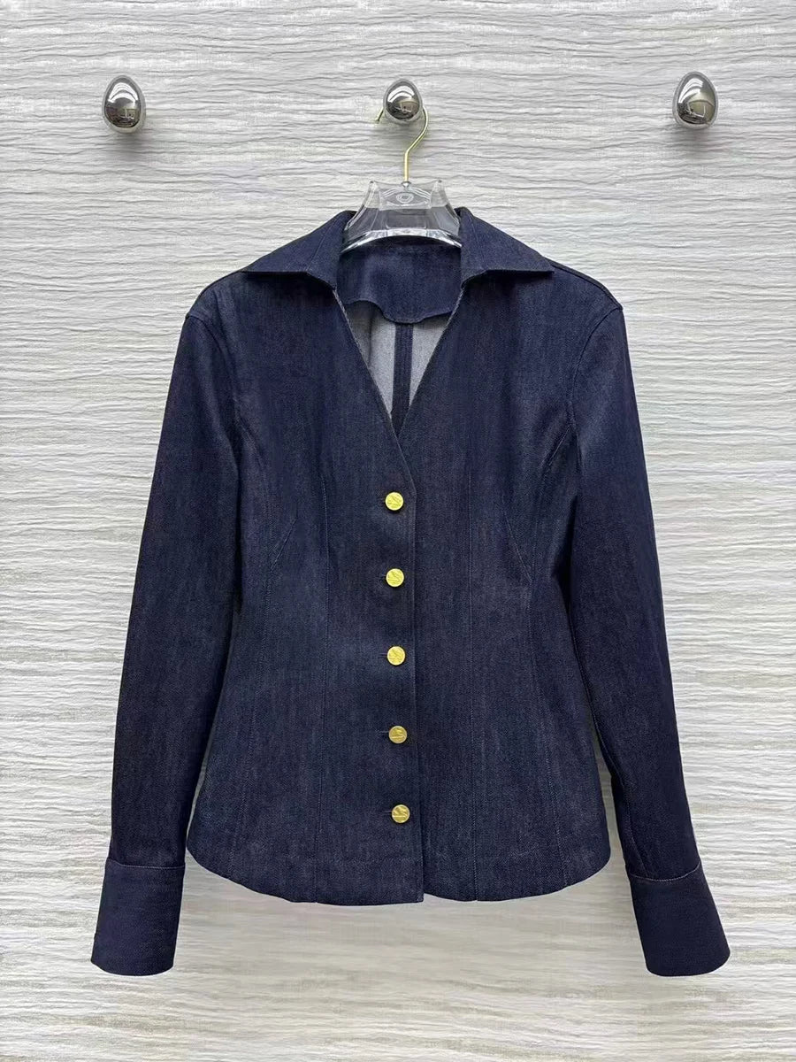 Navy blue jacket with gold buttons on a hanger against a textured white wall.