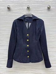 Navy blue jacket with gold buttons on a hanger against a textured white wall.