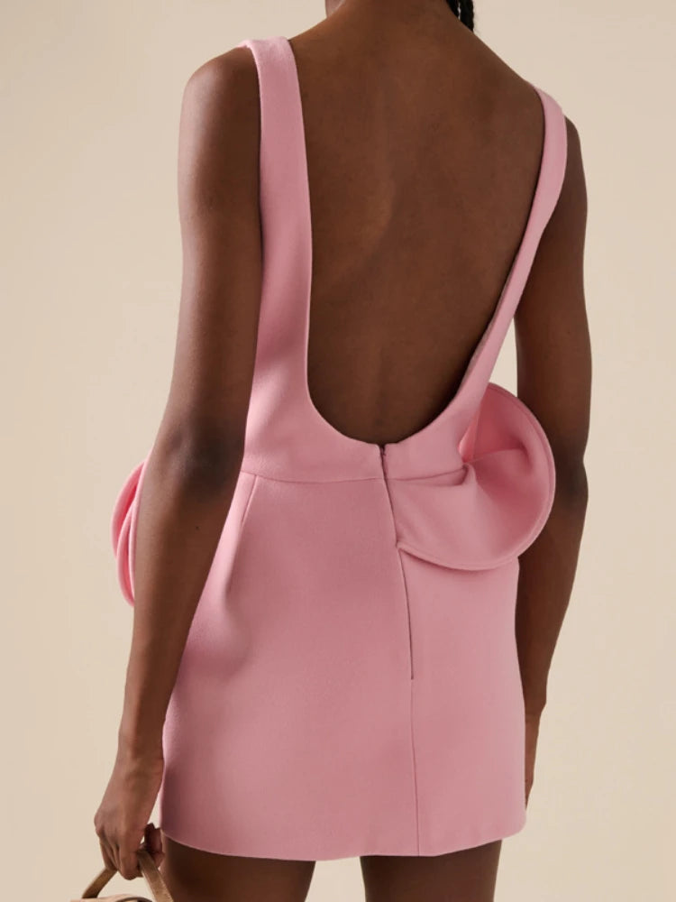 Pink dress with cut-out back on a beige background