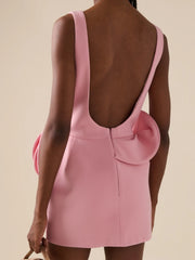 Pink dress with cut-out back on a beige background
