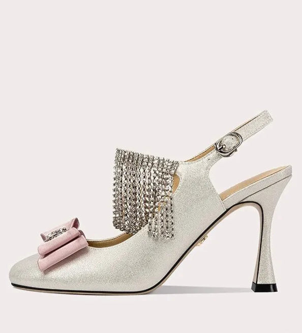 High-heeled shoe with decorative bow and tassel on a white background