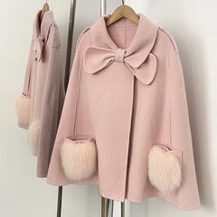 Detail of pink cape coat's bow and fur pocket