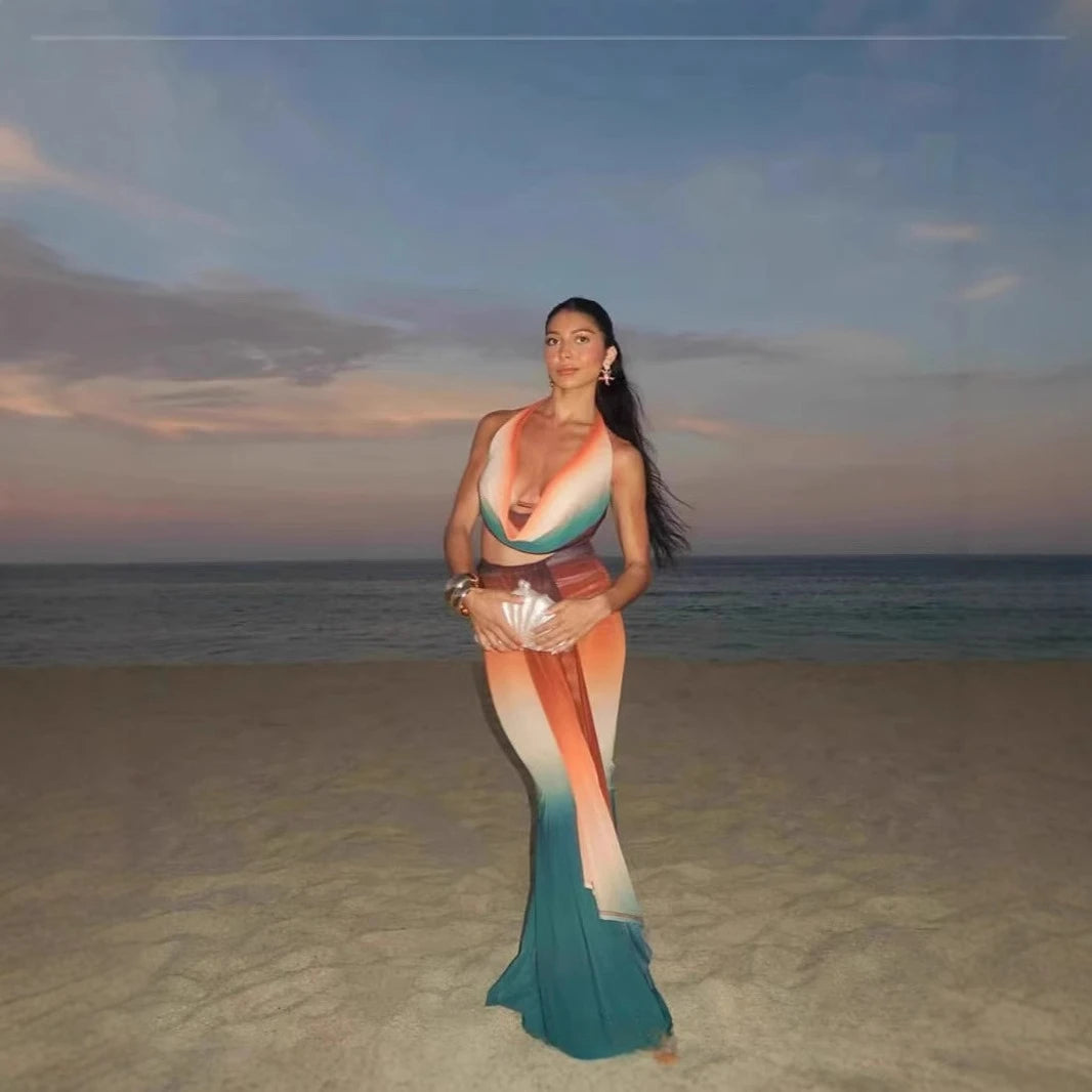 Woman in a colorful mermaid tail on a beach at sunset
