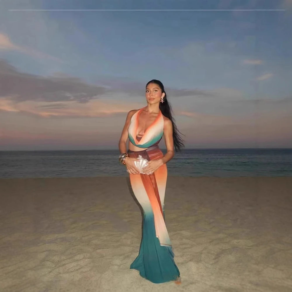 Woman in a colorful mermaid tail on a beach at sunset