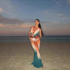Woman in a colorful mermaid tail on a beach at sunset