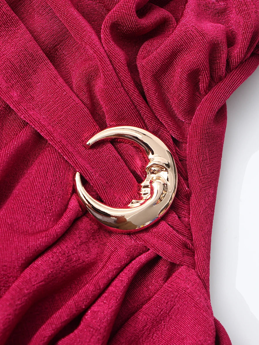 Red fabric with a gold crescent moon and star brooch