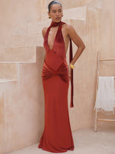 Woman wearing a red evening gown in a neutral setting