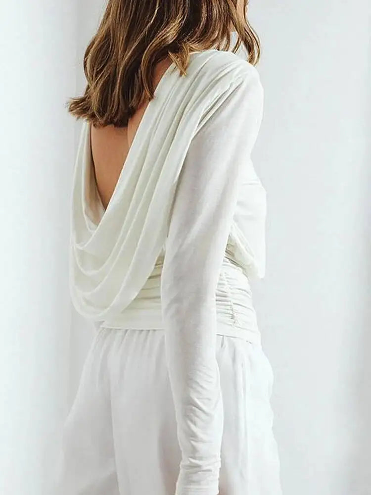 White long-sleeve dress with draped back on a plain background