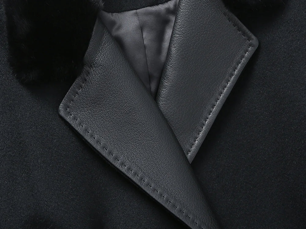 Close-up of a dark coat with leather collar and trim