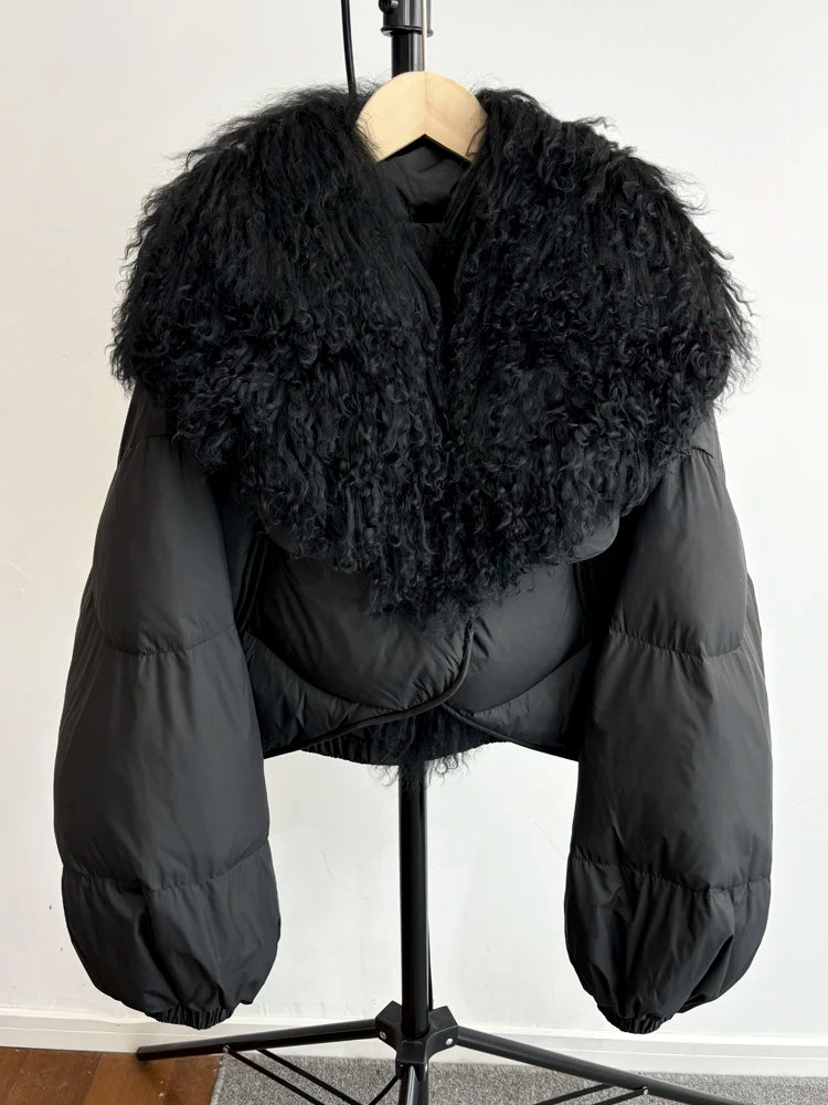 Black cropped puffer jacket with a large black curly textured fur collar and full sleeves.