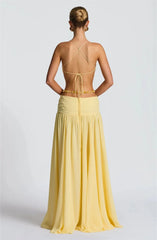 Woman wearing a yellow dress with a backless design on a white background