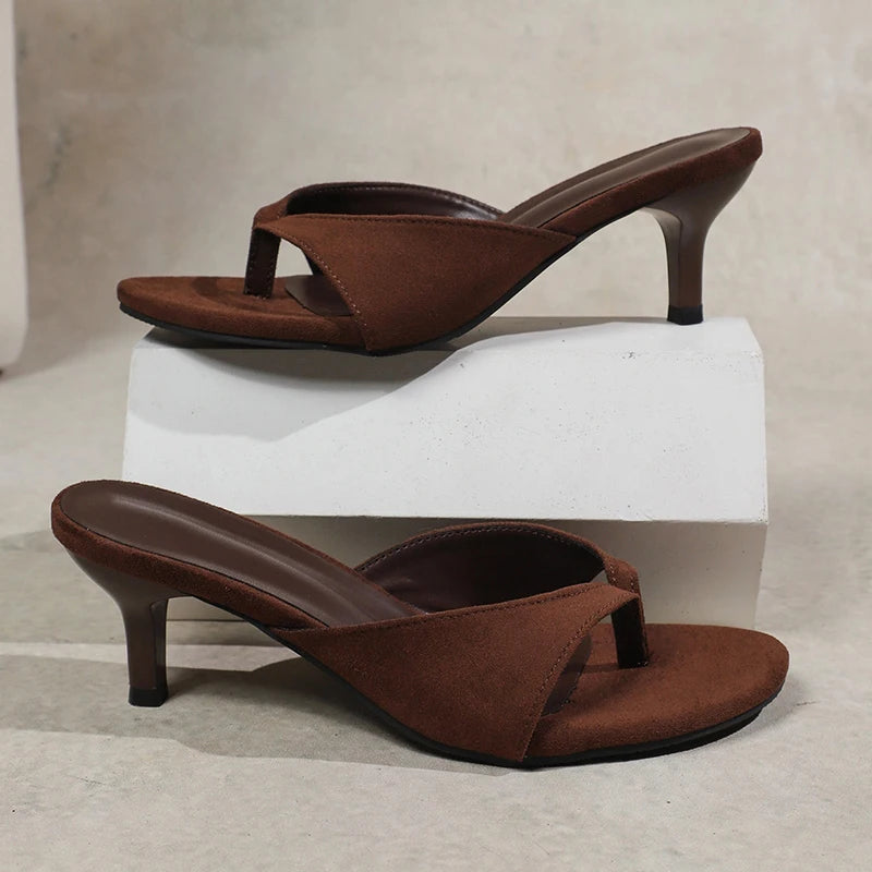Brown high-heeled sandals on a light gray background