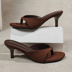 Brown high-heeled sandals on a light gray background
