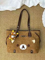 Brown bear applique tote bag with teddy bear charm on textured background
