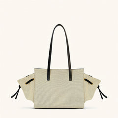 Beige tote bag with black handles and straps on a white background