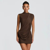 Woman wearing a brown draped dress on a light gray background