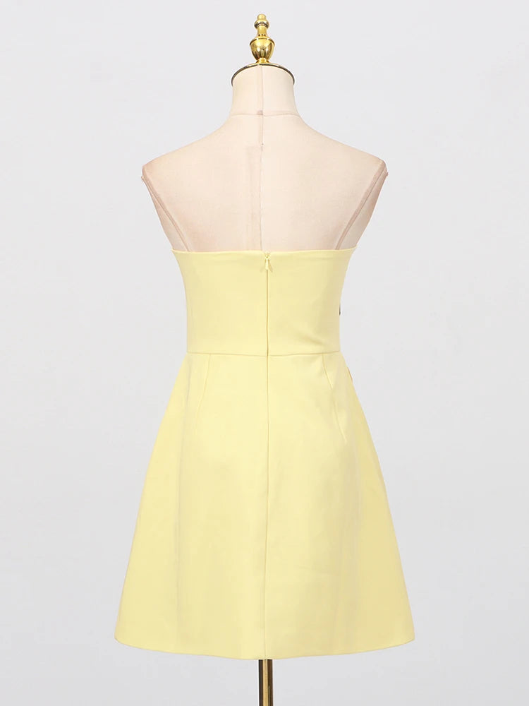 Yellow strapless dress on a mannequin against a white background