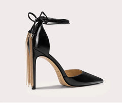 Black high-heeled shoe with gold accents on a light gray background