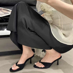 Person wearing black high-heeled shoes with a blurred background