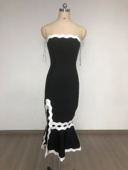 Black dress with white lace details on a mannequin against a plain background