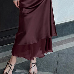 Maroon satin skirt worn by a person on a city street.