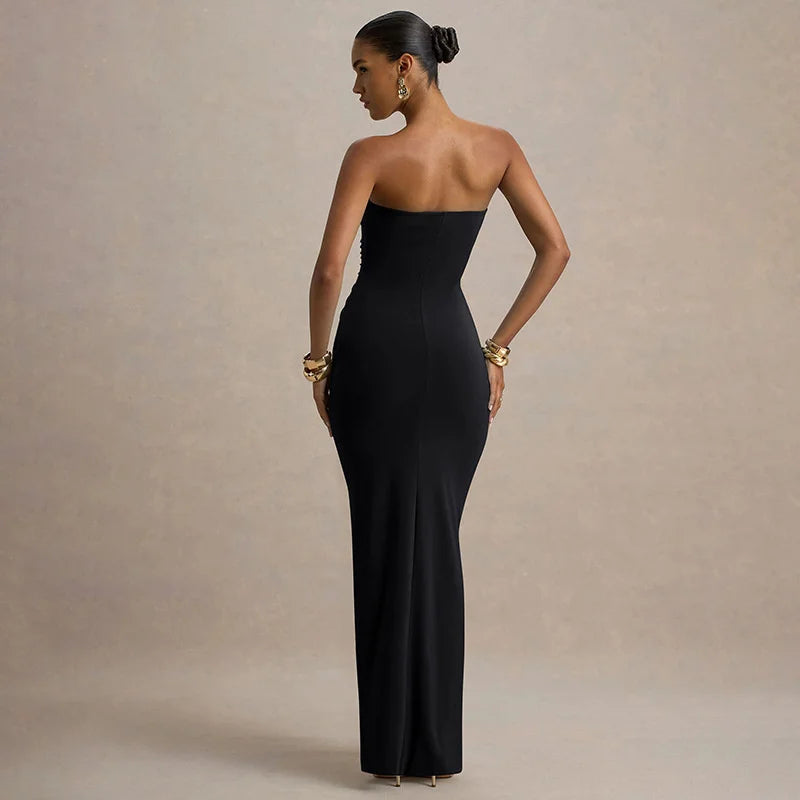 Woman wearing a black strapless gown against a beige background