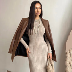Woman wearing a brown coat over a beige dress with a neutral background
