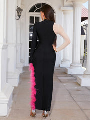 Woman wearing a black jumpsuit with pink feather details in an elegant outdoor setting.
