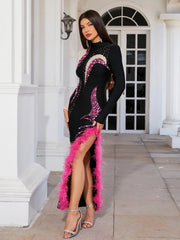 Woman in a black and pink dress with feather details standing in front of a white building.