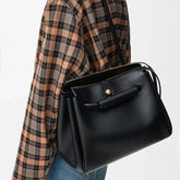 black microfiber leather handbag with top handle and strap