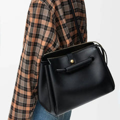 black microfiber leather handbag with top handle and strap