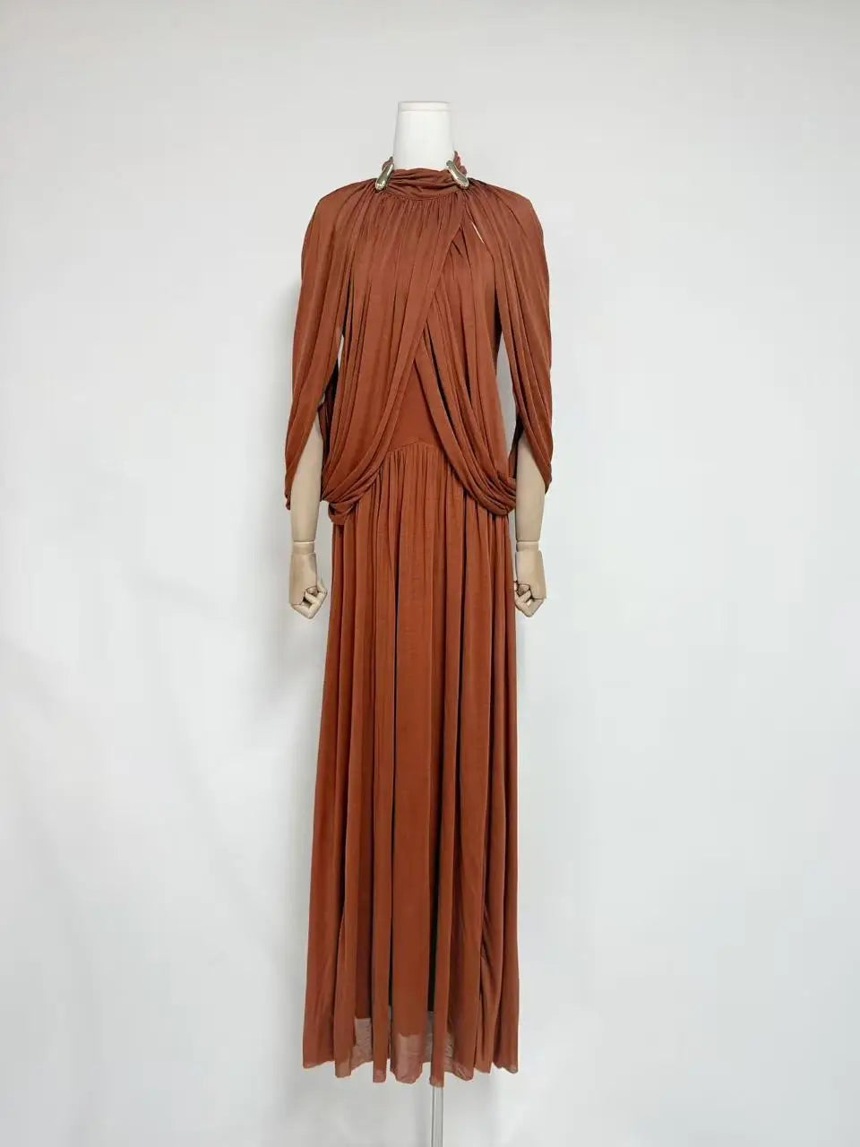 Brown evening gown on a mannequin against a white background